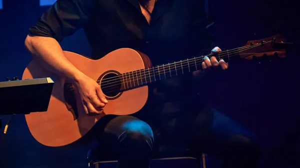 男性の手がアコースティックギタを演奏するイメージ — ストック写真