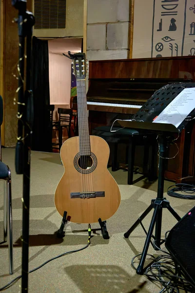 Bir Akustik Gitar Görüntüsü Bir Müzik Standının Yanında Duruyor — Stok fotoğraf
