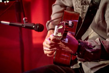 Erkek ellerinin akustik guita çaldığı görüntü