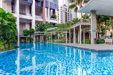 Güneydoğu Asya, Singapur, Kasım 2022: Singapur 'da genel kullanım için güzel bir tropikal bahçesi ve yüzme havuzu olan modern yüksek katlı konut. Konut kiralama kavramı. 