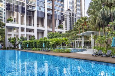 Güneydoğu Asya, Singapur, Kasım 2022: Singapur 'da genel kullanım için güzel bir tropikal bahçesi ve yüzme havuzu olan modern yüksek katlı konut. Konut kiralama kavramı. 