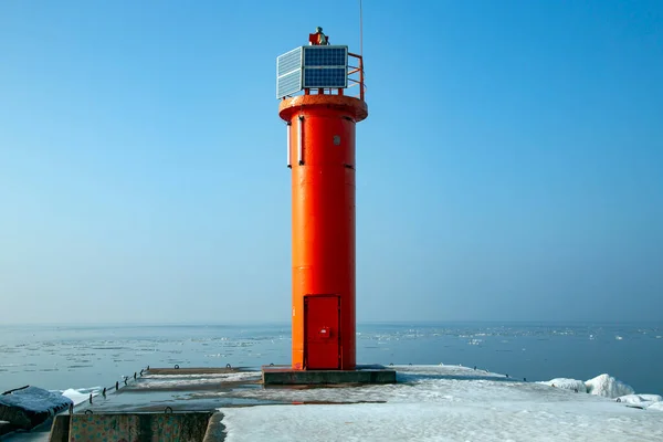 Navigation red lighthouse with solar panels on Mangalsala pier in Baltic sea located at Riga sea port, Latvia, Europe