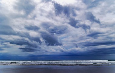 Majestic dramatic sunset sky with large and dark rain clouds in evening time over the Andaman Sea in Langkawi island, Malaysia