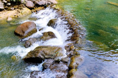 Beautiful deep forest waterfall in Thailand. A cascading waterfall in the woods during summer. South-East Asia.