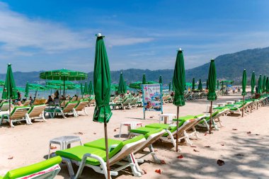 THAILAND, PHUKET, FEBRUARY, 2023: Patong sahilindeki dinlenme alanı güneş pansiyonları ve şemsiyelerle. Phuket, Tayland 'daki güneşli tropik tatil beldesi. 