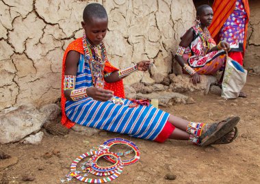 AFRICA, KENYA, MAYIS, 2016 - Masai Mara kabilesinden geleneksel örgü ören ve Afrika, Kenya 'da boncuklu mücevher satan bir kadının portresi