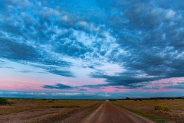 Tarangire Ulusal Parkı, Tanzanya, Afrika 'daki savananın üzerinde kümülüs bulutları olan renkli günbatımı gökyüzü.