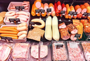 LATVIA, RIGA, MARCH, 2023: şarküteri bölümünde çeşitli et ürünleri sergilenen gösteri, Riga. - Letonya. Farklı üreticilerden geniş et ürünleri seçimi.