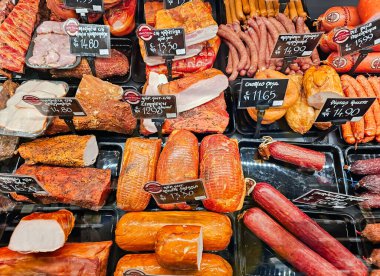 LATVIA, RIGA, MARCH, 2023: şarküteri bölümünde çeşitli et ürünleri sergilenen gösteri, Riga. - Letonya. Farklı üreticilerden geniş et ürünleri seçimi.