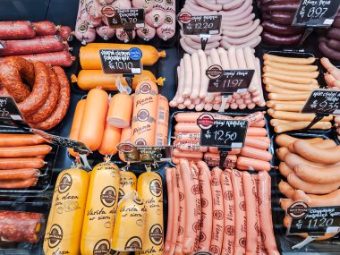 LATVIA, RIGA, MARCH, 2023: şarküteri bölümünde çeşitli et ürünleri sergilenen gösteri, Riga. - Letonya. Farklı üreticilerden geniş et ürünleri seçimi.