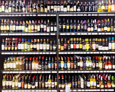 Letonya, Riga, Nisan 2023 - Riga, Letonya 'daki alışveriş merkezindeki çeşitli üzüm bağlarından kırmızı ve beyaz şaraplarla dolu büyük bir bölüm