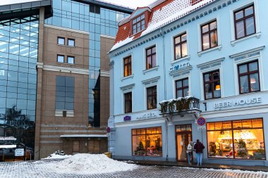 LATVIA, RIGA, FEBRUARY, 2023: Letonya 'nın başkenti Riga' da bir kış akşamında Lido Bira Evi 'nin büyük ve sıcak camlı olduğu antik gotik bina.