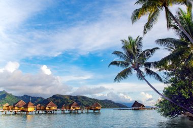 Bora Bora Adası, Tahiti 'de deniz aşırı bungalovlar ve lagün boyunca uzanan ahşap bir köprü. Romantik balayı yeri.