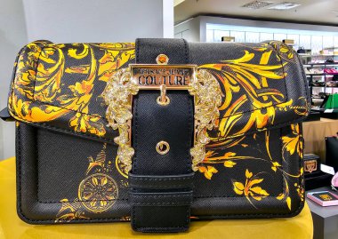 LATVIA, RIGA, APRIL, 2023 - Stockmann alışveriş merkezinde altın tasarımlı Versace Jeans Couture çanta. Riga, Letonya. Şirket logosuna sahip İtalyan tasarımcıların görüntüsü.