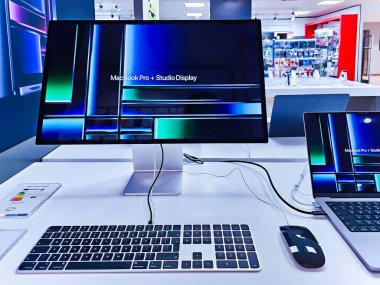 LATVIA, RIGA, APRIL, 2023 - Letonya, Riga 'daki alışveriş merkezinde Stüdyo Ekran 5k Retina monitörüne bağlı yeni bir Mac Book Pro bilgisayarıyla modern elektronik Showroom