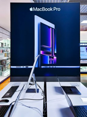 LATVIA, RIGA, APRIL, 2023 - Letonya, Riga 'daki alışveriş merkezinde Stüdyo Ekran 5k Retina monitörüne bağlı yeni bir Mac Book Pro bilgisayarıyla modern elektronik Showroom