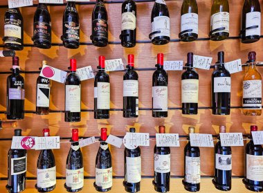 Letonya, Riga, Nisan 2023 - Eski tarz ahşap lüks vitrinleri olan modern şarap butiği mağazası. Dünyanın her yerinden çeşitli üreticilerin şaraplarıyla dolu raflar. Riga, Letonya