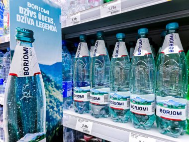 LATVIA, RIGA, MAYIS, 2023: Borjomi bir süpermarket rafındaki maden suyu. Gürcistan cam ve mineral suyu - Borjomi maden suyu üreticisi. Şişe içecekler ve alkolsüz içecekler..