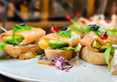 Marbella, Costa del Sol, İspanya 'da beyaz tepside somonlu İspanyol mezeleri ve ahşap şişler.