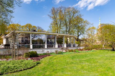 Arka plandaki güzel bahar ağaçları ve çalı çalıları Letonya 'nın başkenti Riga' daki Kronvalda Park 'taki Özgürlük Anıtı.