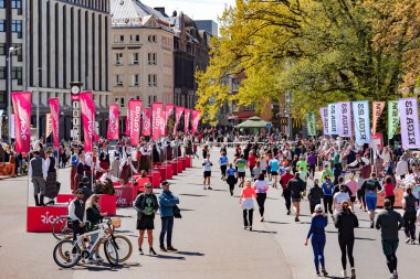LATVIA, RIGA, 23, APRIL, 2023: Letonya ulusal kostümlü dansçılar özel platformlarda durup Rimi Riga Maratonu 2023 'te koşan insanlarla tanışıyorlar. Maraton yıllık bir etkinliktir..