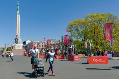 LATVIA, RIGA, 23, APRIL, 2023: Letonya ulusal kostümlü dansçılar özel platformlarda durup Rimi Riga Maratonu 2023 'te koşan insanlarla tanışıyorlar. Maraton yıllık bir etkinliktir..