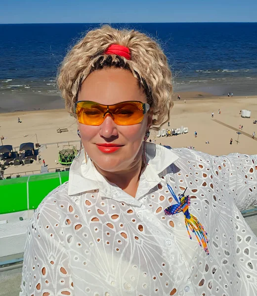 Latvia Jurmala Majori 2023 ラトビアのジュルマラのバルト海を背景に 黄色のサングラスで巻き毛のきれいな女性 — ストック写真