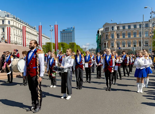 Latvia Riga May 2023 青年管弦乐队穿着节日彩衣 手中拿着乐器 靠近拉脱维亚首都里加老城自由大道上的自由纪念碑 — 图库照片