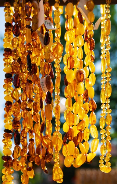 stock image Necklaces amber of different colors and sizes on Jomas street in Majori, Jurmala. Souvenir or gift of stones of amber for tourists. Sun stone. Natural mineral material for jewelry. Amber texture.