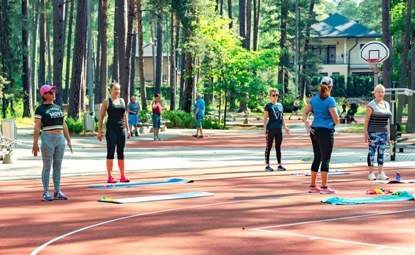 Latvia Dzintari Jurmala June 2023 一群妇女在拉脱维亚Jurmala的Dzintari松树森林公园的室外体育场健身 健康生活方式概念和肌肉灵活性 — 图库照片