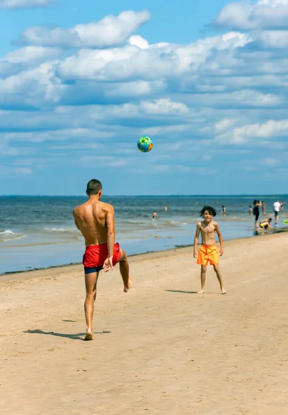 ラトビア Jurmala Julmala 2023年7月 アスレチックマンは ジュルマラのマオリにあるバルト海のビーチで少年と一緒にサッカーをしています スポーツ 子供時代 アクティブなライフスタイルの概念 — ストック写真