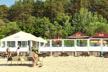 LATVIA, JURMALA, 18, JULY, 2023 - İnsanlar Dzintari, Jurmala, Letonya 'daki Baltık deniz plajında dinlenmenin keyfini çıkarıyorlar. Jurmala 'da sağlıklı ve spor yaşam tarzı ve aktiviteleri.
