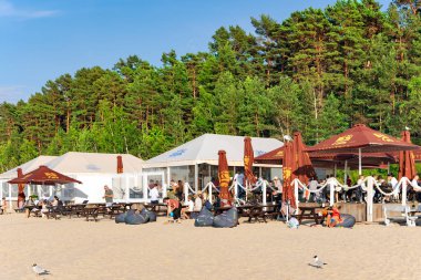 LATVIA, JURMALA, 18, JULY, 2023 - İnsanlar Dzintari, Jurmala, Letonya 'daki Baltık deniz plajında dinlenmenin keyfini çıkarıyorlar. Jurmala 'da sağlıklı ve spor yaşam tarzı ve aktiviteleri.