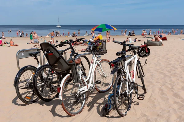 Latvia Jurmala July 2023 自転車ラックに立っているバルト海沿岸に沿って自転車に乗るための自転車 所有者は ジュラマラのマジョリで海で泳いでいます ラトビア — ストック写真
