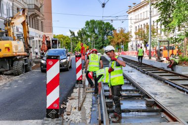 LATVIA, RIGA, 25, HAZİRAN, 2023: Çalışma üniformalı işçiler ve özel ekipmanlarla Letonya 'nın başkenti Riga' daki kentsel karayollarının onarımı üzerinde çalışmalar sürdürülüyor.