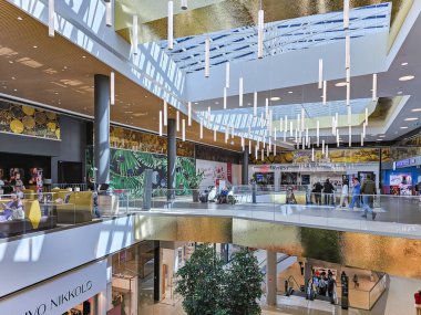 LATVIA, RIGA, 25, JULY, 2023 - Letonya 'nın başkenti Riga' daki Brivibas Caddesi 'ndeki Alfa alışveriş merkezinde güneş ışığı için cam tavanlı modern iç mekan.