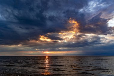 Jurmala 'da Baltık Denizi' nin üzerinde kara fırtına bulutlarıyla sihirli gün batımı