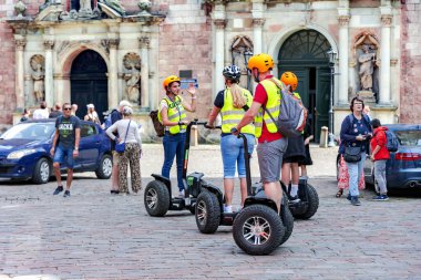 LATVIA, RIGA, 08, AUGust, 2023: Turistler elektrikli scooterların önünde duruyorlar Segway ve Riga Old Town, Letonya 'daki rehber hikayeyi dinliyorlar 
