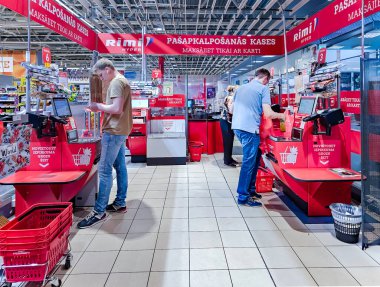 LATVIA, RIGA, 10, AUGust, 2023: Rimi süpermarketindeki müşterilerle self-servis kontrolleri, Riga. - Letonya. Rimi Baltic, 270 perakende mağazası olan Baltık devletlerinde büyük bir perakende operatörü..