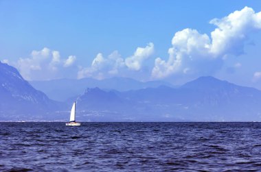 Kuzey İtalya 'nın Lombardy bölgesinde arka planında İtalyan Alpleri olan Como Gölü' nde yalnız bir yelkenli.. 