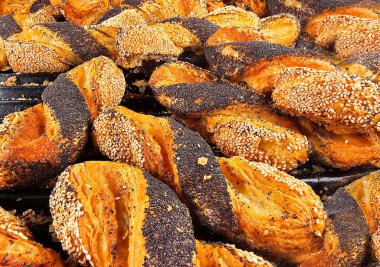 İçinde haşhaş ve susam tohumları olan taze pişmiş çörekler ve yakın plan doldurulmuş badem ezmesi.