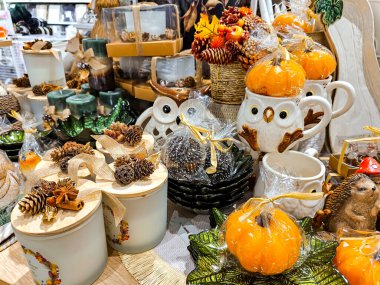 LATVIA, RIGA, 13, SEPTEMBER, 2023: alışveriş merkezindeki Cadılar Bayramı kutlaması için parlak dekoratif sofra takımı ve dekorasyonlar, Riga. - Letonya. Sonbahar dekoru, mumlar, çiçekler, balkabakları ve yemekler..