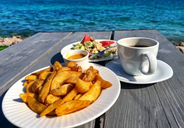 Açık bir kafede hafif bir öğle yemeği. Salata ve patates kızartması. Kisezers gölünde, Riga 'da. - Letonya. Açık hava eğlencesi konsepti.