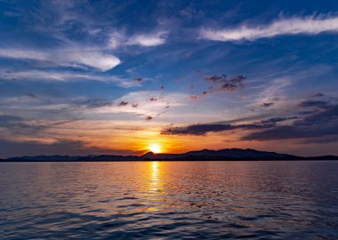 Akşam vakti, Tayland 'ın Phuket Adası' ndaki Andaman Denizi üzerinde muhteşem dramatik bir günbatımı gökyüzü. Sakin, rahatlatıcı güneş ışığı yaz titreşimleri.