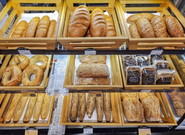 LATVIA, RIGA, 28, SEPTEMBER, 2023: Yeni pişmiş ekmekle birlikte ahşap raflar süpermarkette satışa hazır, Riga. Letonya