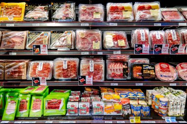 ITALY, MILAN, 25, AĞUSTOS, 2023: Parma jambonu ve İtalya 'da bir İtalyan süpermarketinin şarküterisinin şarküteri paketlenmiş diğer etleri