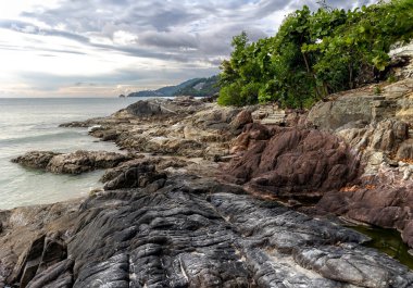 Phuket Tayland 'da Patong plajı yakınlarındaki Kalim sahilinde kayaların olduğu güzel bir deniz manzarası. Tayland 'daki tropik cennet. Phuket turistlerin uğrak yeridir.