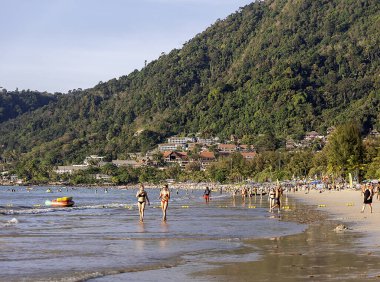 THAILAND, PHUKET, 18, FEBRUARY, 2023: Tatilciler Patong Sahili, Phuket, Tayland 'da Andaman Denizi kıyılarında yürürler. Phuket Adası 'ndaki zeki gezgin için Patong plajı. Tayland