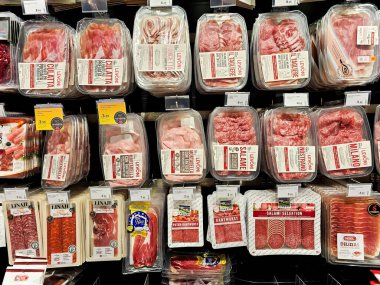 LATVIA, RIGA, 10, HAZİRAN, 2024: Büyük gıda bölümünde çeşitli et ürünleriyle dolu raflar, Riga. - Letonya. Farklı üreticilerden geniş et ürünleri seçimi.
