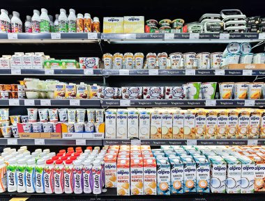  LATVIA, RIGA, 10, HAZİRAN, 2024: Süpermarket raflarında Alpro Soya sütü ve yoğurt ürünleri. Alpro, organik ve bitkisel olmayan ürünleri pazarlayan bir Avrupalı şirket..